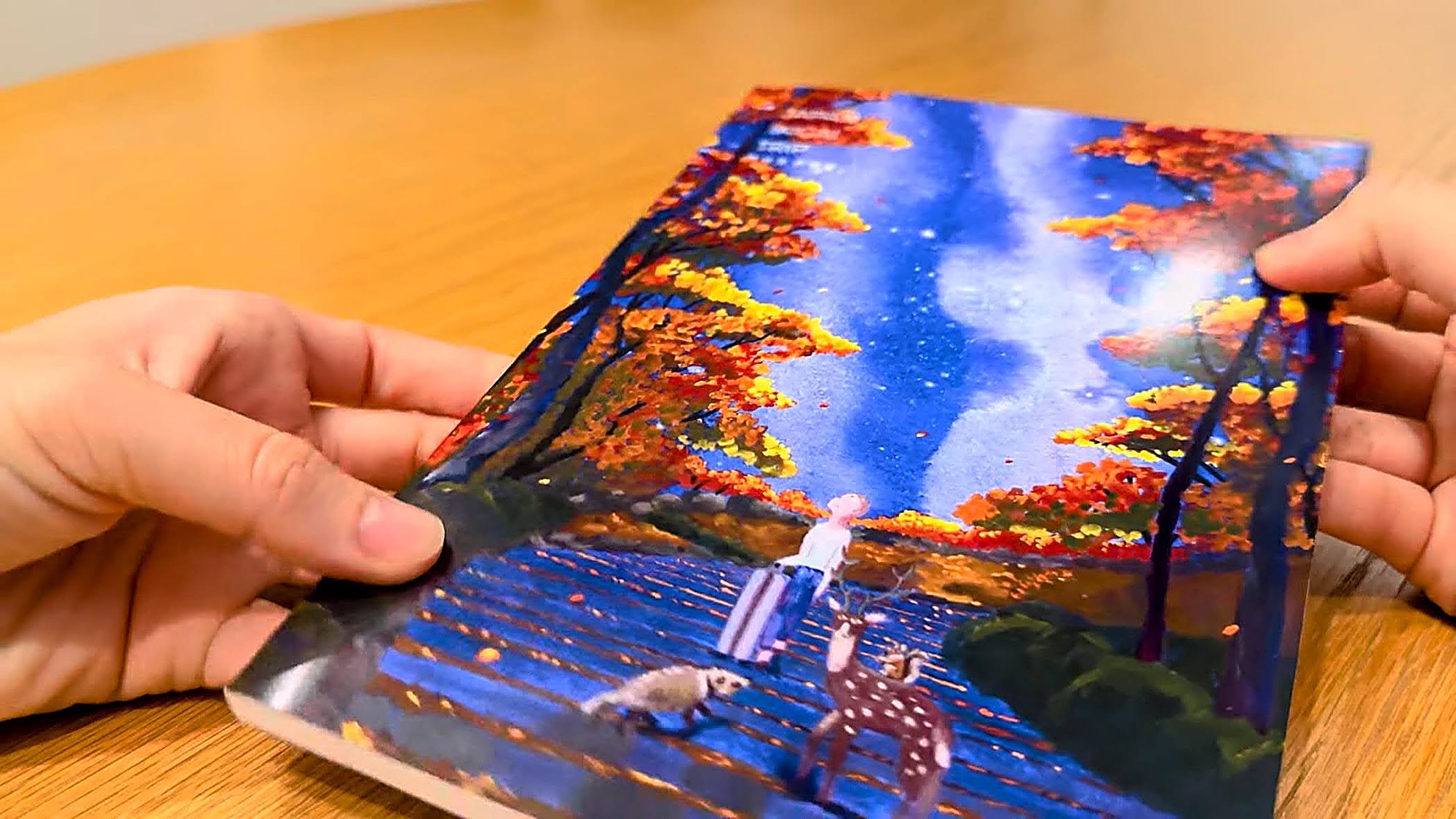 Two hands opening a Travel Bible on a table