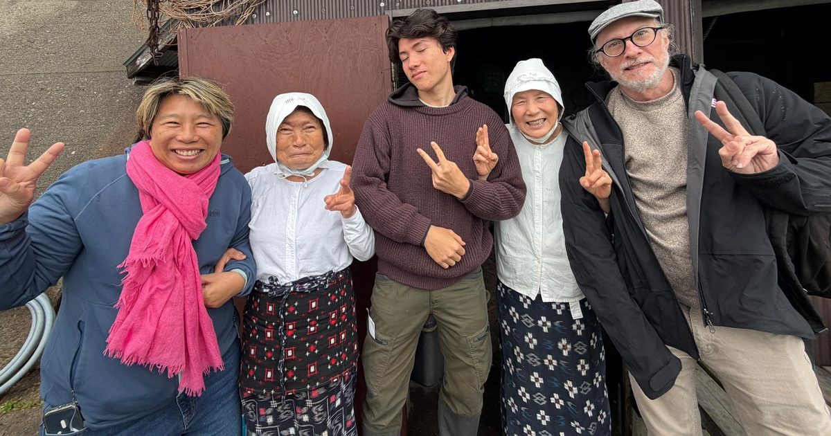 A traveler spending time with local hosts in the Japanese countryside